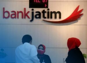 Transfer BRI Ke Bank Jatim Transfer BRI Ke Bank Jatim dapat dilakukan dengan cara yang sangat mudah. Bank BRI sendiri adalah salah satu lembaga perbankan milik BUMN yang cukup besar di Indonesia. Jaringannya sendiri memang sangat luas dan banyak sekali digunakan oleh berbagai kalangan. Sedangkan untuk Bank Jatim sendiri termasuk salah satu bank daerah yang ada di Jawa Timur. Bank yang satu ini milik BUMD yang Statusnya juga cukup besar dan banyak juga digunakan untuk kebutuhan transaksi di wilayah tersebut. Adapun untuk penjelasan lebih lengkapnya seputar Transfer BRI Ke Bank Jatim dan informasi lainnya bisa kalian simak pada uraian dibawah ini. Transfer BRI Ke Bank Jatim Transfer BRI Ke Bank Jatim bisa dipraktekkan dengan beberapa metode mudah. Sama saat kalian melakukan Cara Transfer BRI Ke Flip. Nah dalam artikel kali ini, akan dibahas 3 metode transfer yang tersedia saat mengirim dana atau uang dari Bank BRI ke Bank Jatim, yakni lewat ATM, BCA Mobile, dan SMS Banking BCA. Transfer BRI Ke Bank Jatim Lewat ATM Metode pertama adalah melalui mesin ATM. Nasabah hanya perlu membawa kartu ATM BRI ke gerai ATM terdekat untuk bisa transfer ke Bank Jatim. Sesampainya di gerai ATM, kalian bisa ikuti langkah-langkah dibawah ini : Masukkan kartu debit ke slot mesin ATM Pilih bahasa layanan “Bahasa Indonesia” Jika sudah, masukkan 6 digit PIN ATM BRI Pilih “Menu Lain”, dan lanjut pilih “Transfer” Berikutnya, pilih “Dari Rekening Tabungan” Setelah itu, pilih “Ke Rekening Bank Lain” Masukkan “Kode Bank + No Rekening Tujuan” Masukkan nominal uang yang ingin ditransfer Klik “Ya” pada halaman konfirmasi jika data transfer sudah benar Terakhir, nasabah akan mendapatkan struk bukti transfer Transfer BRI Ke Bank Jatim Lewat Mobile Banking Cara kedua adalah melalui aplikasi BRI mobile, aplikasi mobile banking ini bisa didownload pada smartphone Android maupun iPhone. Tentunya cara ini bisa kalian coba setelah rekening aktif dan terdaftar di aplikasi BRI mobile. Berikut cara transfer BRI ke Bank Jatim lewat BRImo: Pertama, buka akses aplikasi BRImo di smartphone Pilih menu "BRI mobile", dan pilih menu "Transfer" Kemudian pilih menu "Transfer ke Bank Lain" Cari “Bank Jatim” pada pilihan yang tersedia Lanjut masukkan no rekening BCA tujuan Masukkan nominal transfer yang diinginkan Setelah itu, masukkan 6 digit PIN BRI mobile Tunggu pemberitahuan SMS dari no 3300 Kalau sudah ada pemberitahuan, maka proses transfer berhasil Transfer BRI Ke Bank Jatim Lewat SMS Cara yang terakhir adalah melalui SMS banking. Layanan SMS banking ini hanya menggunakan ponsel untuk mentransfer uang tanpa perlu pergi ke ATM. Berikut caranya : Pastikan bahwa rekening milikmu telah terdaftar SMS banking Jika belum terdaftar, maka lakukan registrasi terlebih dahulu Setelah itu, buka menu SMS dari perangkat ponsel mu Tulis SMS dengan format TRANSFER KODE BANK + NO REKENING TUJUAN NOMINAL PIN ATM. Jika format sudah diketik, kirim SMS tersebut ke no 3300 Nasabah akan mendapatkan SMS konfirmasi transfer Setelah muncul keterangan sukses, maka kalian bisa mengecek rekeningmu untuk memastikan transferan sudah masuk atau belum. Kode Transfer Bank BCA Ke Bank Jatim Bagi pembaca yang berencana untuk melakukan proses transfer melalui ATM Bank BRI, maka tentunya harus mengetahui tentang kode transfer Bank Jatim terlebih dahulu. Setiap lembaga perbankan di Indonesia tentunya memiliki kode khusus yang berguna untuk membedakan antara bank yang satu dengan lainnya. Demikian juga dengan Bank Jatim, adapun kode yang dimiliki oleh bank Jatim adalah 114. Kode ini bisa kalian masukkan sebelum nomor rekening. Biaya Transfer Bank BCA Ke Bank Jatim Hal yang menjadi pertanyaan selanjutnya adalah mengenai biaya transfer yang dikenakan. Biaya transfer bank BRI ke bank jatim pada dasarnya mengikuti kebijakan dari Bank BRI. Berikut untuk detail biaya lengkapnya : Transfer ke Bank Lain : Biaya : Rp 6.500 per transaksi (melalui ATM, internet banking, dan m-banking). Transfer Menggunakan BI-Fast : Biaya: Rp2.500 per transaksi. Jadi nasabah akan dikenakan biaya tambahan sebesar itu ditambah dengan nilai transfer yang kalian kirimkan. Sampai disini paham ? Tips Menghemat Biaya Transfer Antar Bank Nasabah BRI dapat menyiasati mahalnya biaya transfer antar bank setiap kali akan bertransaksi dengan beberapa tips dibawah ini : 1. Buka Rekening Bank dengan Minim Biaya Admin Untuk menghemat pengeluaran biaya transfer antar bank, nasabah bisa mempertimbangkan untuk membuka rekening yang menawarkan biaya admin yang paling kecil. 2. Gunakan Rekening Bank yang Sama Nasabah bisa memiliki 1 atau 2 rekening bank di bank yang berbeda. Misalnya seperti Bank BRI dan Bank Jatim. Jika kalian merasa memiliki frekuensi transaksi yang besar ke bank tersebut. Dengan semakin banyak nasabah memiliki rekening bank yang sama, maka kalian tidak akan dibebankan biaya transfer antar bank dan pemrosesan transfer pun juga bisa dilakukan lebih cepat. 2 Tips yang disampaikan di atas juga berlaku untuk transfer ke bank lainnya seperti misalnya, Cara Transfer BRI Ke BCA Digital. Demikianlah, empat cara Transfer BRI Ke Bank Jatim melalui mesin ATM, Mobile Banking, dan SMS Banking yang dapat kami sajikan. Setidaknya pembaca sudah mengetahui informasinya dan bisa mengetahui prosesnya juga. Semoga bermanfaat dan selamat mencoba. Transfer BRI Ke Bank Jatimed